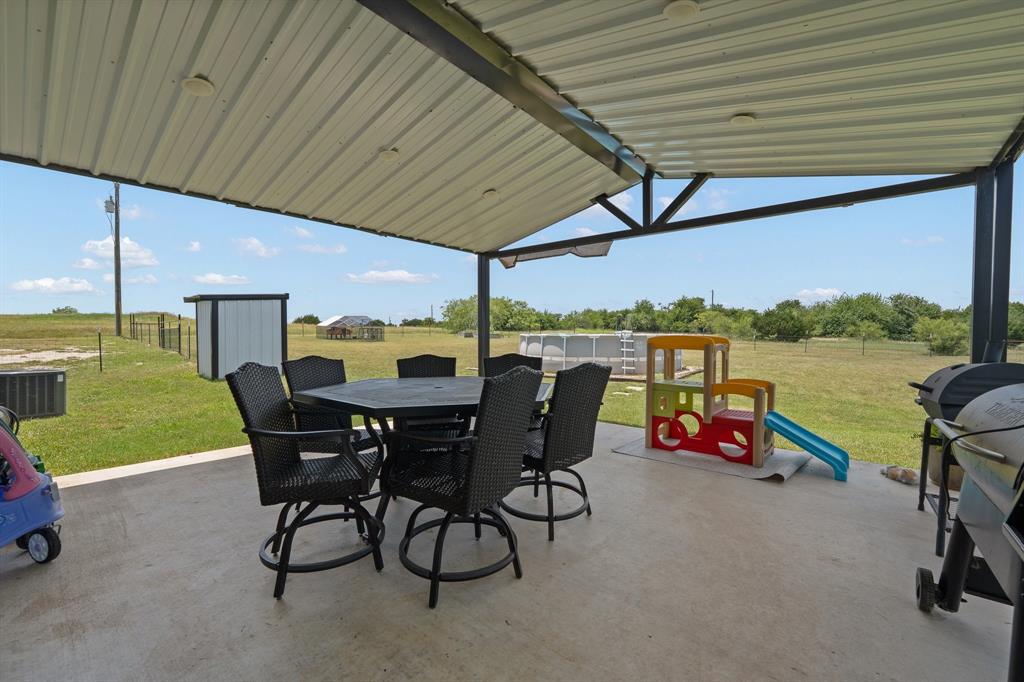 1031 Augustus Court Rio Vista, TX 76093 - Photo 22 of 30 Expansive covered patio with a concrete surface, metal roof, and structural beams