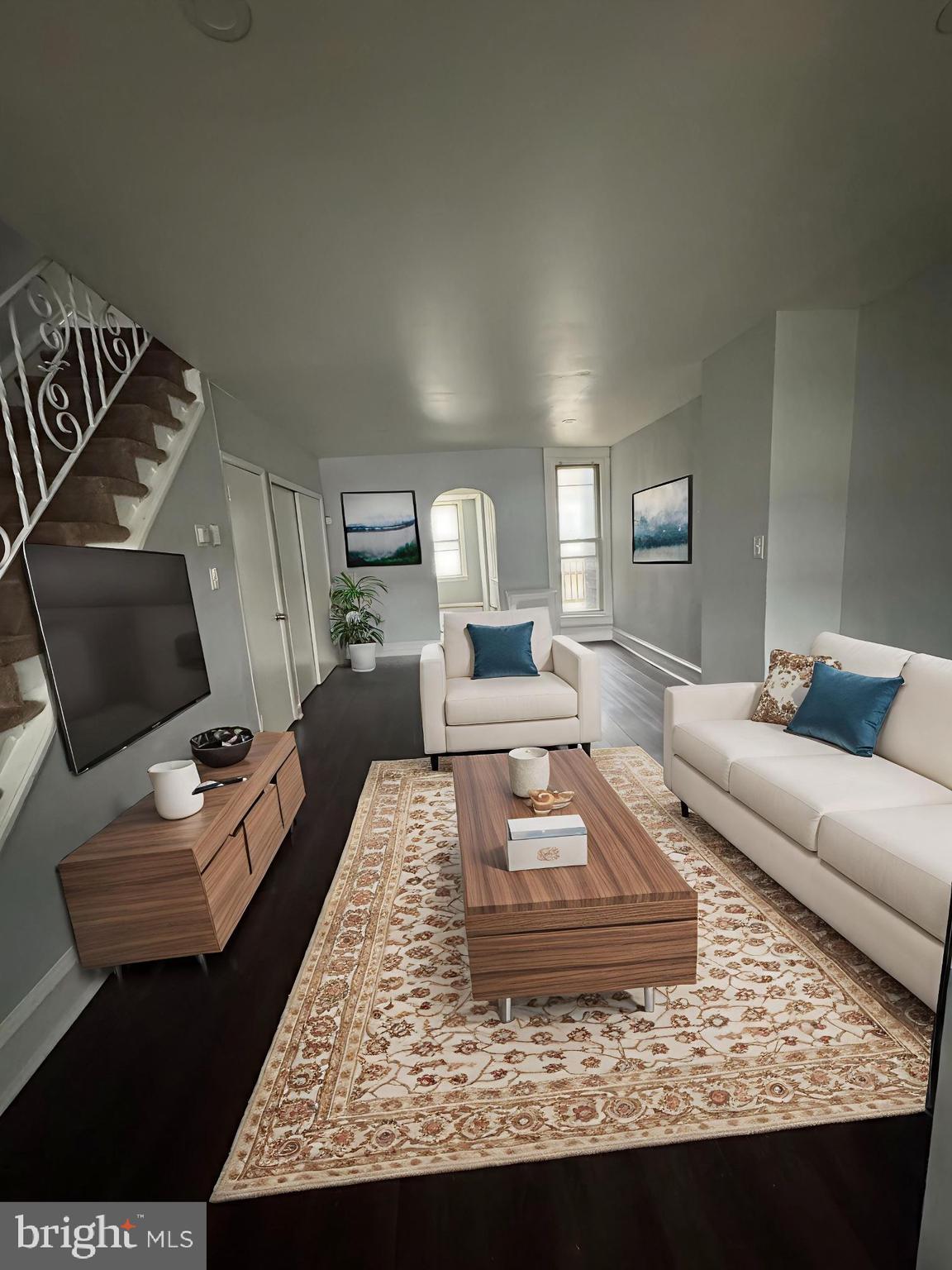 a living room with furniture and a wooden floor