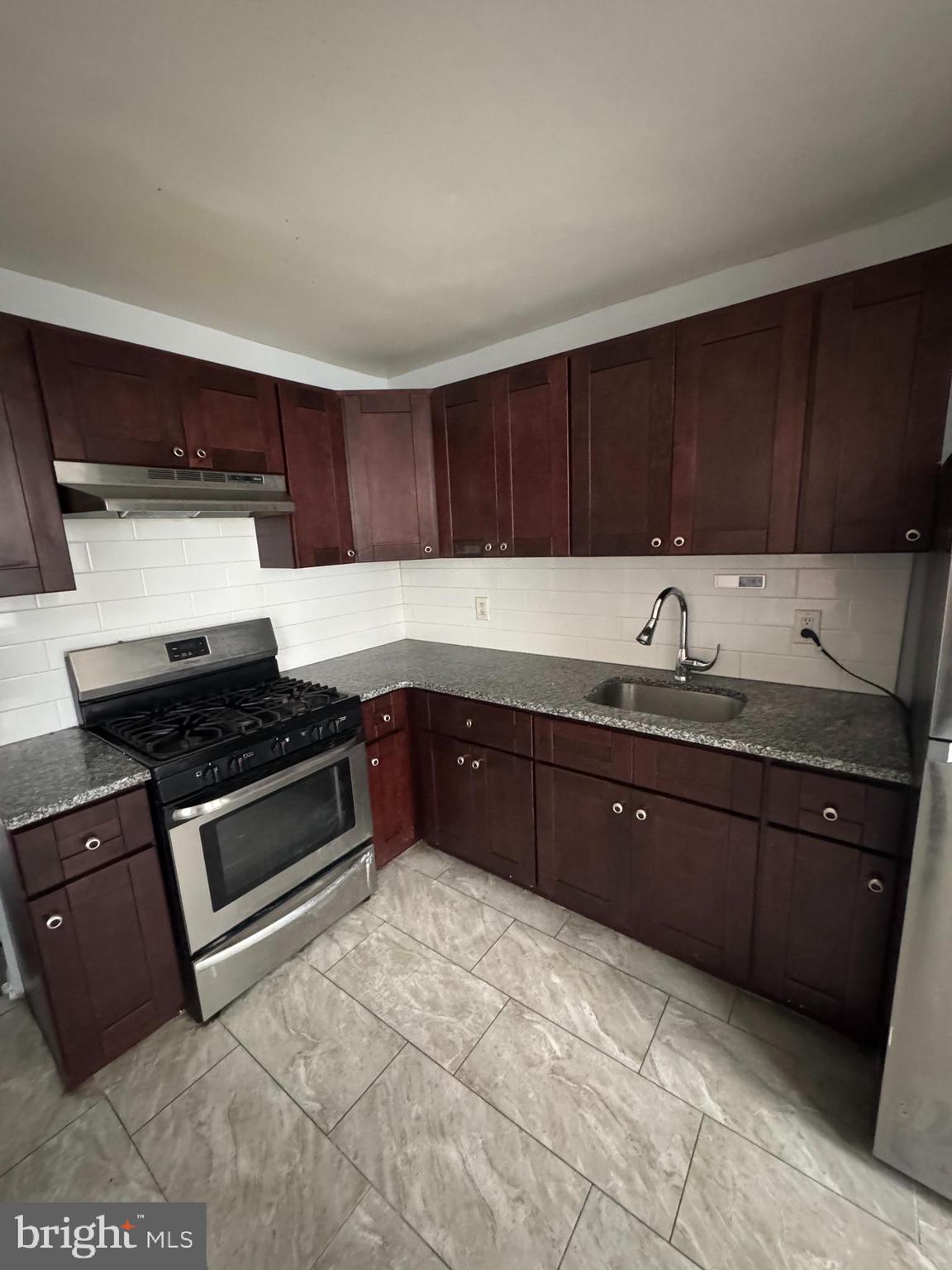 841 Bridge Street Philadelphia, PA 19124 - Photo 6 of 11 a kitchen with granite countertop a sink and a stove