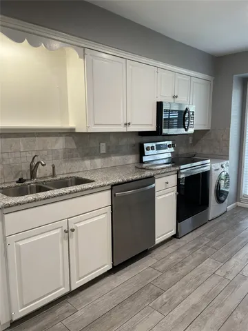 a kitchen with stainless steel appliances granite countertop a sink and cabinets