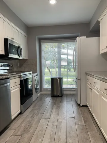 a kitchen with stainless steel appliances a stove sink and microwave