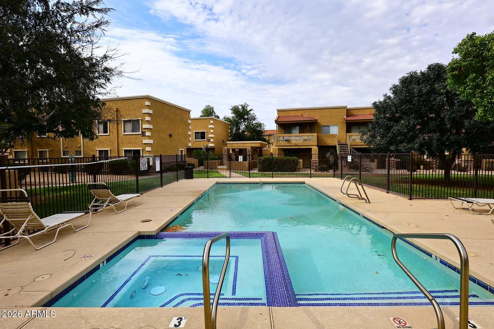 303 North Miller Road, Unit 1007 Scottsdale, AZ 85257 - Photo 27 of 45 a view of a swimming pool with a lounge chairs