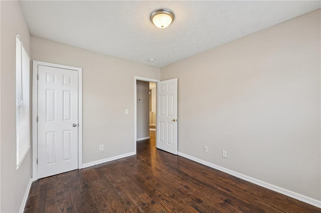 122 Nowell Street Monroe, GA 30655 - Photo 11 of 24 a view of an empty room with wooden floor and a window