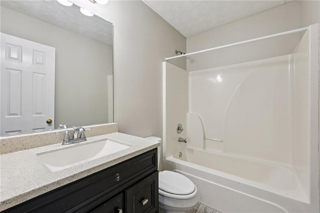 122 Nowell Street Monroe, GA 30655 - Photo 15 of 24 a bathroom with a granite countertop sink a toilet and shower