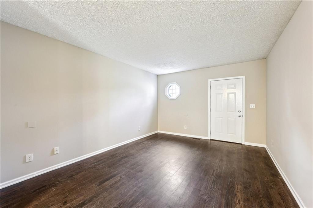 122 Nowell Street Monroe, GA 30655 - Photo 4 of 24 an empty room with wooden floor and windows