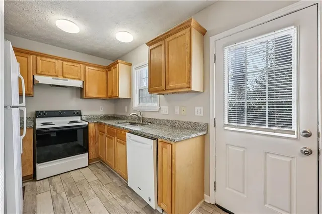 a kitchen with stainless steel appliances granite countertop a stove and a refrigerator
