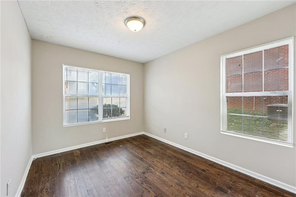122 Nowell Street Monroe, GA 30655 - Photo 10 of 24 an empty room with wooden floor and windows