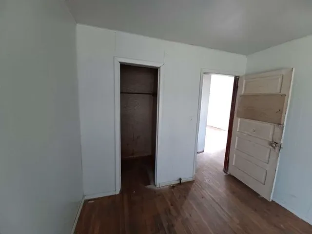 an empty room with wooden floor and closet