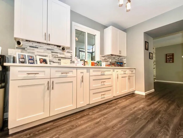 a kitchen with stainless steel appliances granite countertop a stove and white cabinets