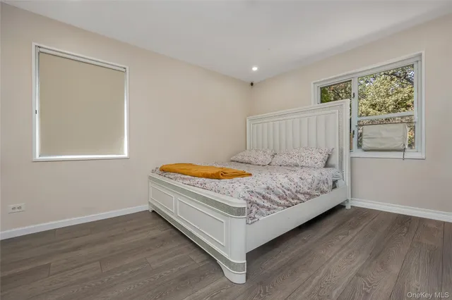 a bed sitting in a spacious bedroom next to a window