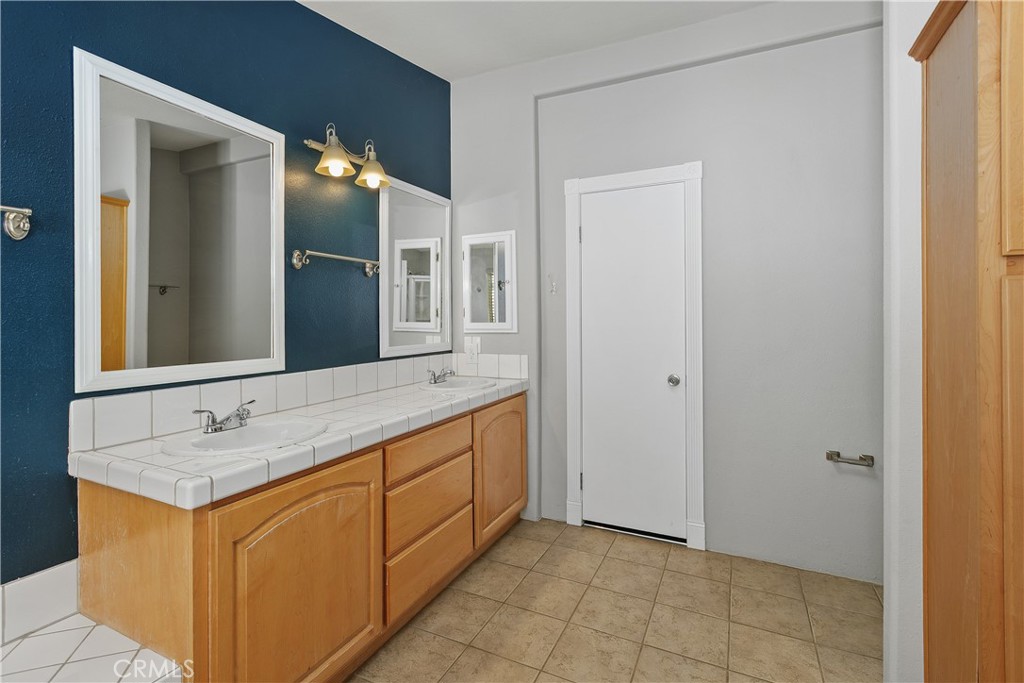 23742 Bundy Canyon Road Wildomar, CA 92595 - Photo 14 of 38 a bathroom with a granite countertop sink and a mirror