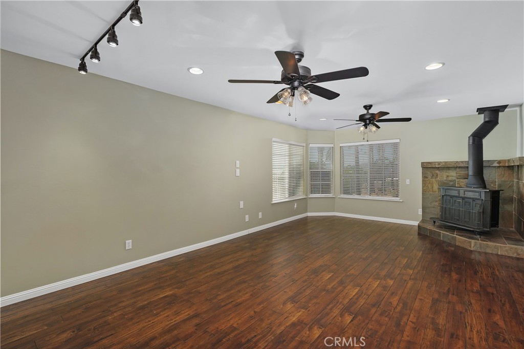 23742 Bundy Canyon Road Wildomar, CA 92595 - Photo 17 of 38 a view of a livingroom with wooden floor and a ceiling fan