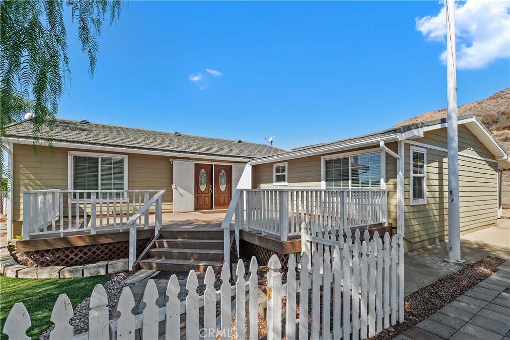 23742 Bundy Canyon Road Wildomar, CA 92595 - Photo 2 of 38 a view of a house with a small yard and wooden fence