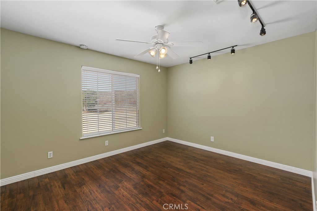 23742 Bundy Canyon Road Wildomar, CA 92595 - Photo 22 of 38 a view of an empty room with wooden floor and a window