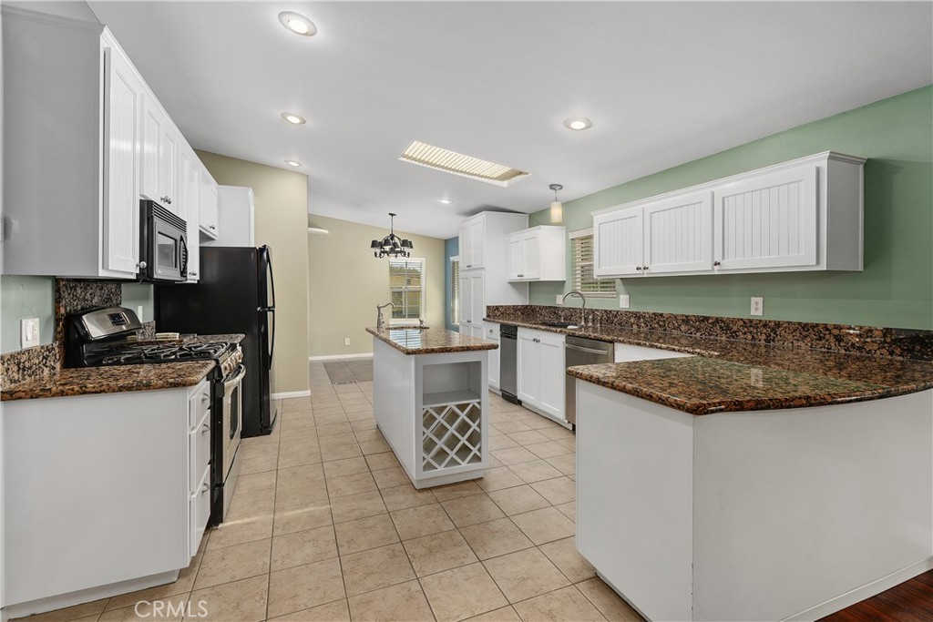 23742 Bundy Canyon Road Wildomar, CA 92595 - Photo 10 of 38 a kitchen with a sink a counter top space cabinets and stainless steel appliances
