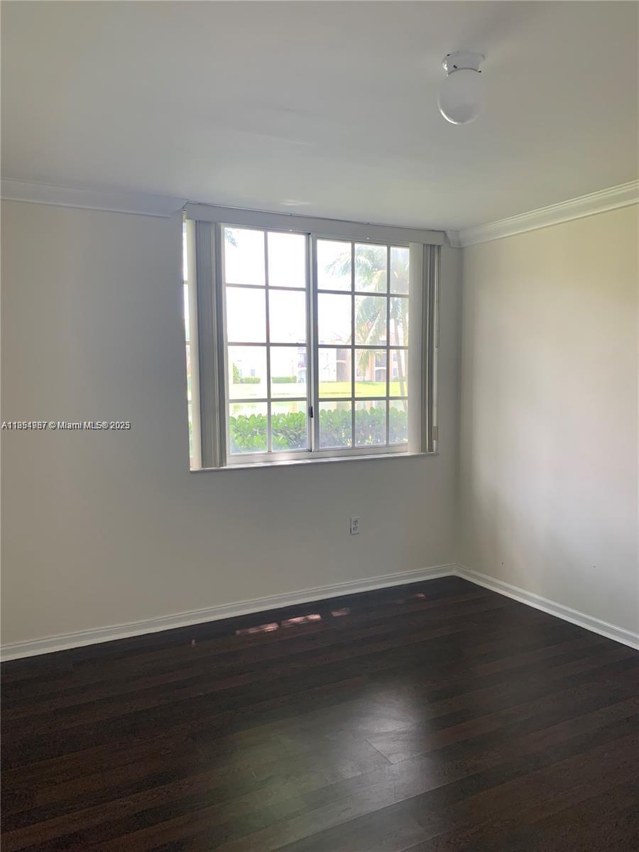 2071 Renaissance Boulevard, Unit 108 Miramar, FL 33025 - Photo 15 of 25 a view of an empty room with wooden floor and a window