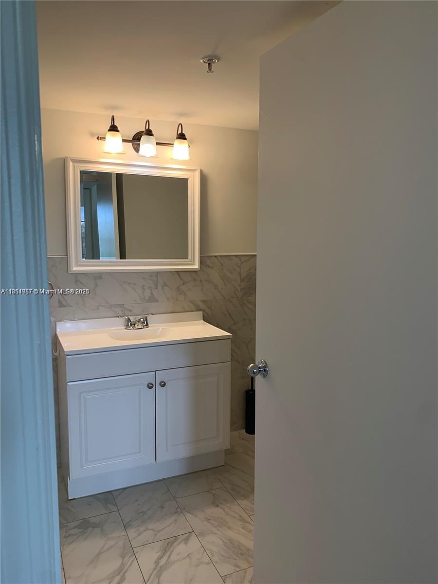 2071 Renaissance Boulevard, Unit 108 Miramar, FL 33025 - Photo 18 of 25 a bathroom with a sink and a mirror