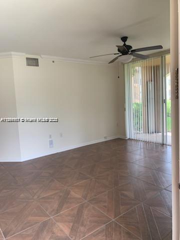 2071 Renaissance Boulevard, Unit 108 Miramar, FL 33025 - Photo 6 of 25 a view of a livingroom with wooden floor and a ceiling fan