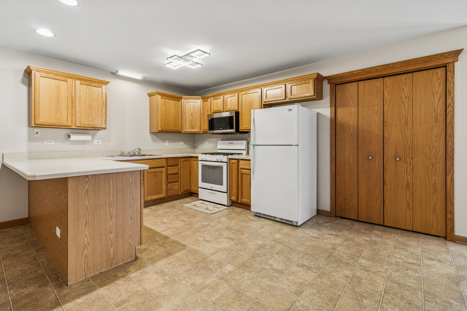 225 Morrow Street, Unit D Somonauk, IL 60552 - Photo 7 of 19 a kitchen with stainless steel appliances granite countertop a stove a refrigerator a sink and dishwasher