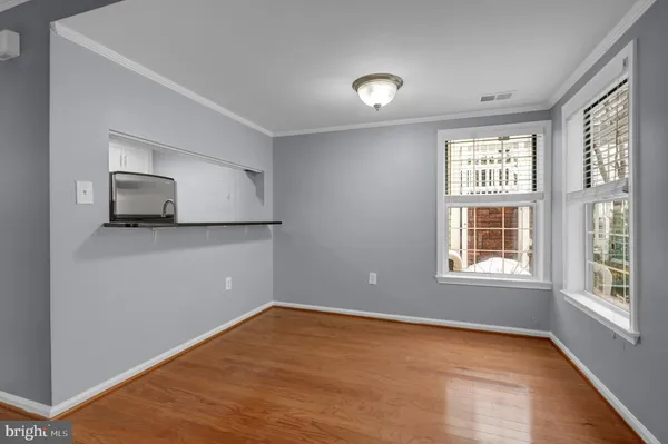 a view of empty room with kitchen and window