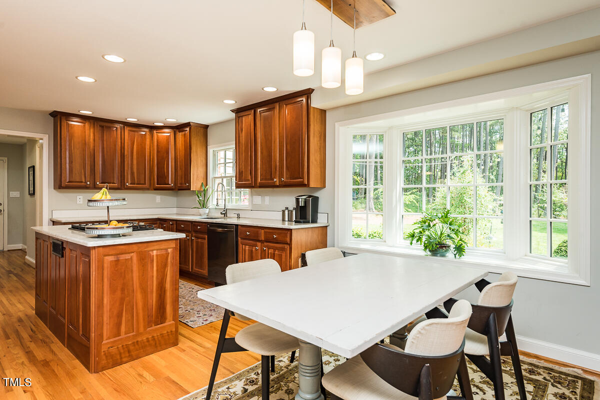 7214 Sunrise Road Chapel Hill, NC 27514 - Photo 18 of 61 a kitchen with granite countertop a stove a sink a dining table and chairs
