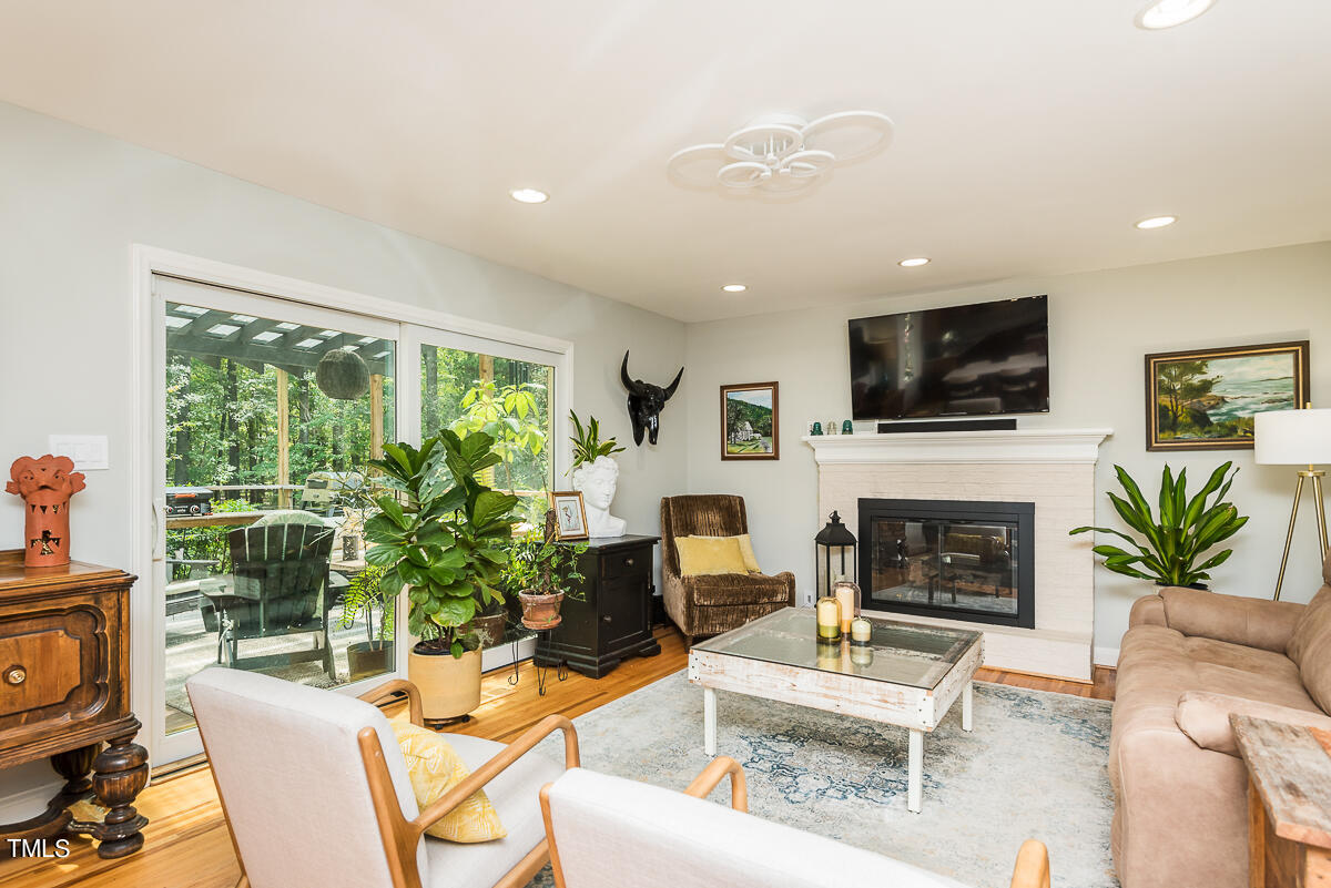 7214 Sunrise Road Chapel Hill, NC 27514 - Photo 19 of 61 a living room with furniture a fireplace and a flat screen tv