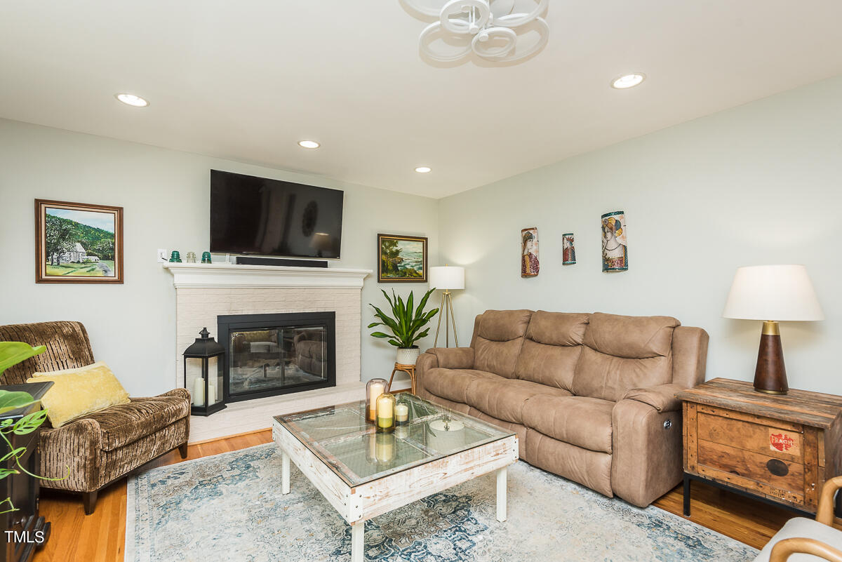 7214 Sunrise Road Chapel Hill, NC 27514 - Photo 20 of 61 a living room with furniture a fireplace and a flat screen tv
