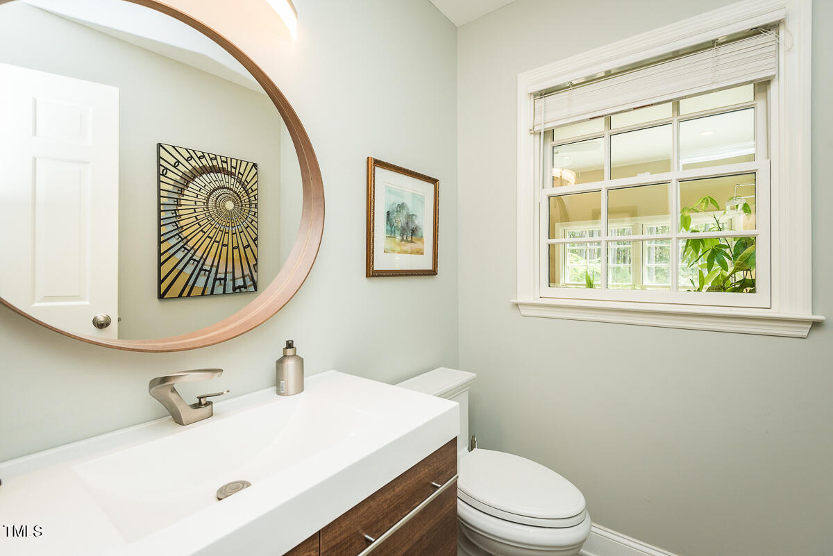 7214 Sunrise Road Chapel Hill, NC 27514 - Photo 26 of 61 a bathroom with a sink a mirror and a toilet