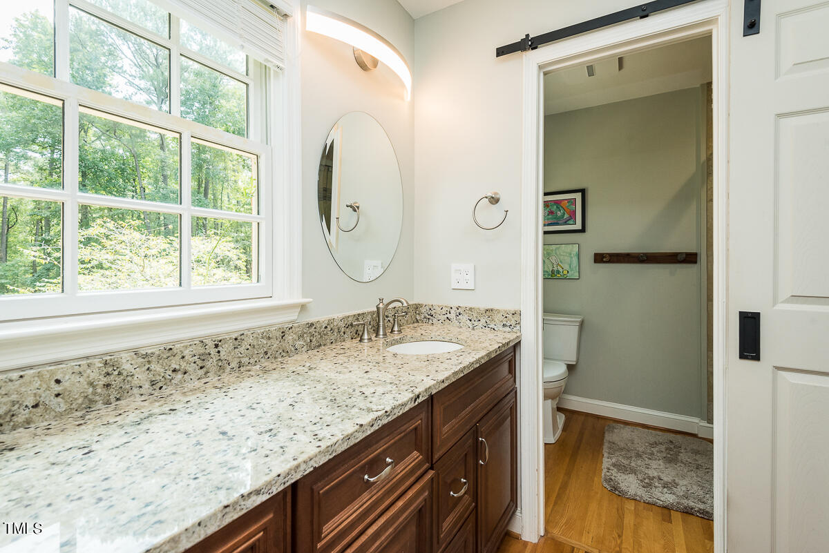 7214 Sunrise Road Chapel Hill, NC 27514 - Photo 29 of 61 a bathroom with a granite countertop sink and a mirror