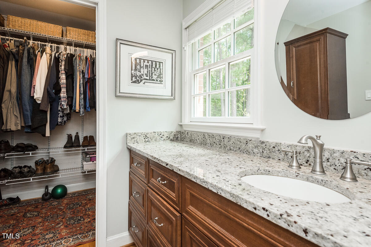 7214 Sunrise Road Chapel Hill, NC 27514 - Photo 30 of 61 a bathroom with a granite countertop sink a mirror and a window