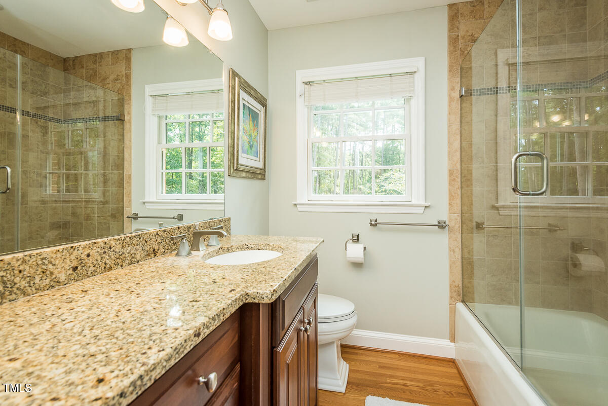 7214 Sunrise Road Chapel Hill, NC 27514 - Photo 32 of 61 a bathroom with a granite countertop sink a toilet and shower