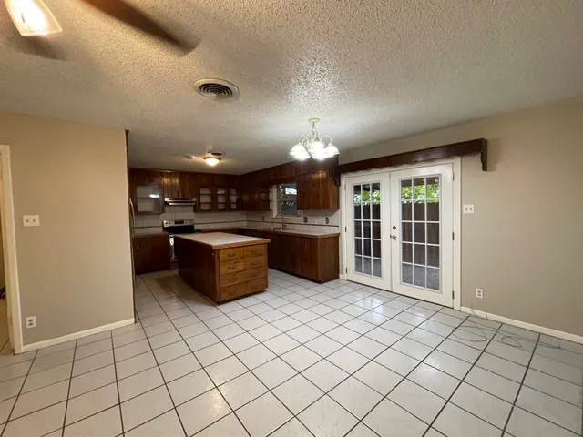 a kitchen with stainless steel appliances kitchen island granite countertop a refrigerator and a sink