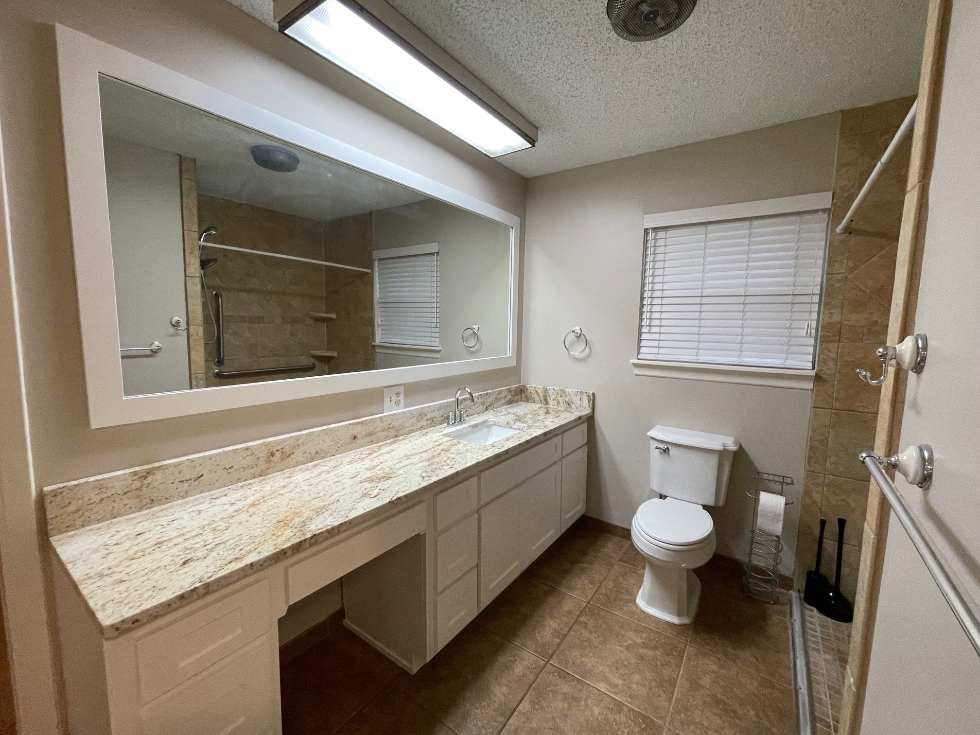 607 Pecan Street Del Rio, TX 78840 - Photo 8 of 10 a bathroom with a granite countertop sink mirror vanity and toilet