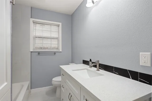 a bathroom with a sink a toilet and a window