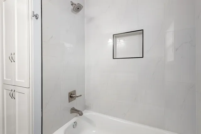 a bathroom with a bathtub and a shower