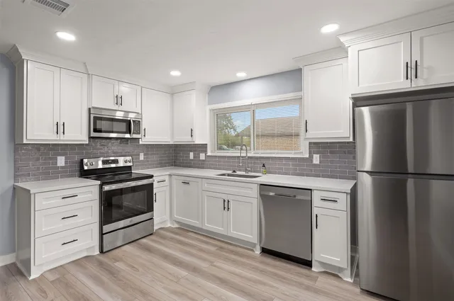 a kitchen with granite countertop a refrigerator stove and sink