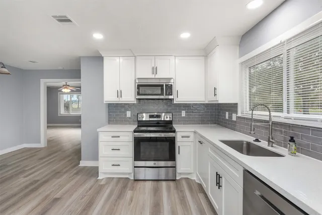 a kitchen with stainless steel appliances granite countertop a sink stove and refrigerator