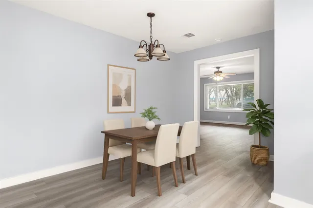 a view of a dining room with furniture wooden floor and a chandelier