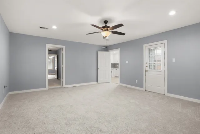 an empty room with a chandelier fan and closet
