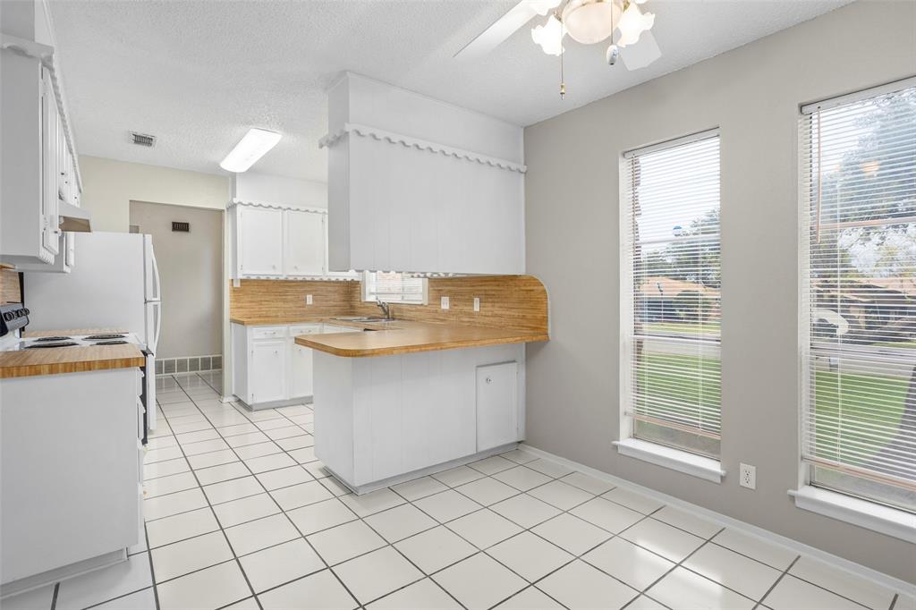 1024 Edgewood Trail Benbrook, TX 76126 - Photo 11 of 28 a view of a kitchen with kitchen island granite countertop a sink cabinets and a window