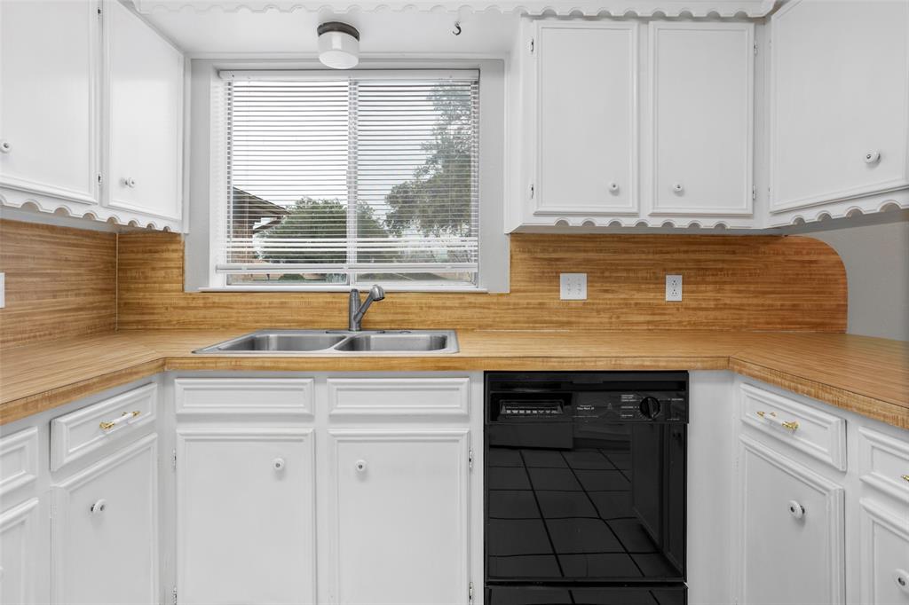 1024 Edgewood Trail Benbrook, TX 76126 - Photo 14 of 28 a kitchen with granite countertop a sink and white cabinets