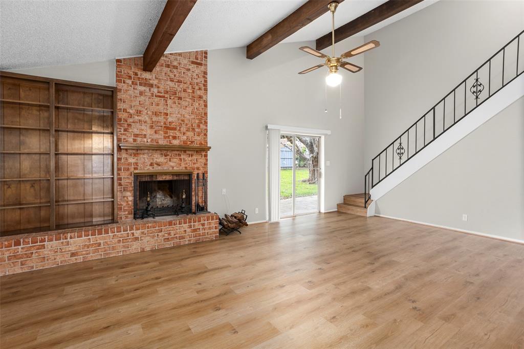 1024 Edgewood Trail Benbrook, TX 76126 - Photo 7 of 28 a view of an empty room with wooden floor a fireplace and a window