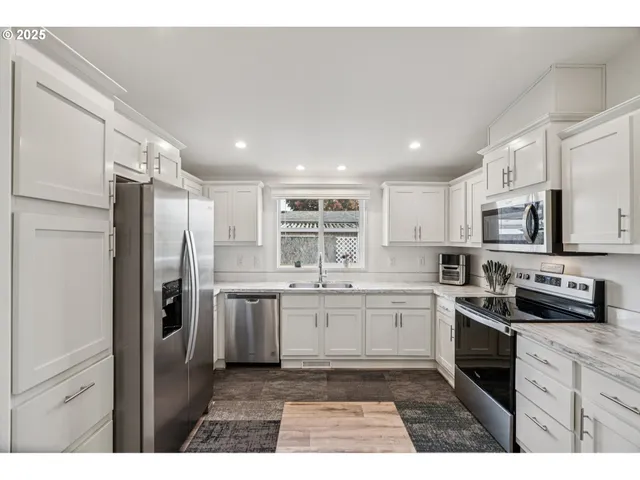 a kitchen with stainless steel appliances granite countertop a refrigerator and a stove top oven