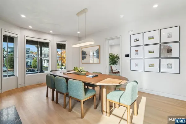 a dining room with furniture a chandelier and wooden floor