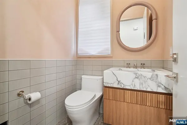 a bathroom with a toilet sink vanity and mirror