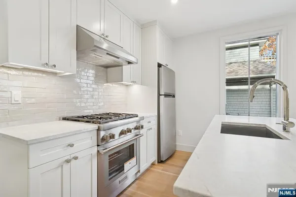 a kitchen with a stove a sink and a refrigerator