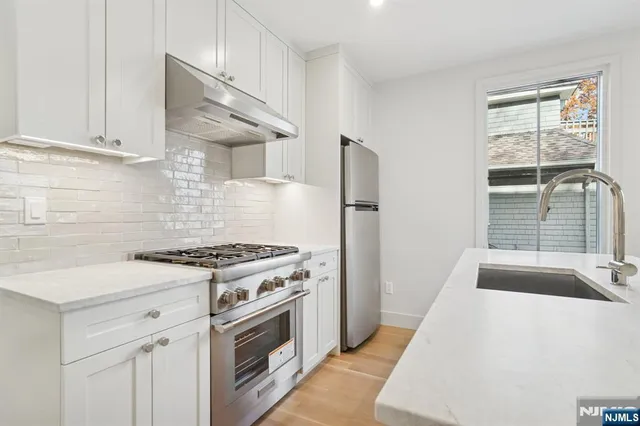 a kitchen with a stove a sink and a refrigerator