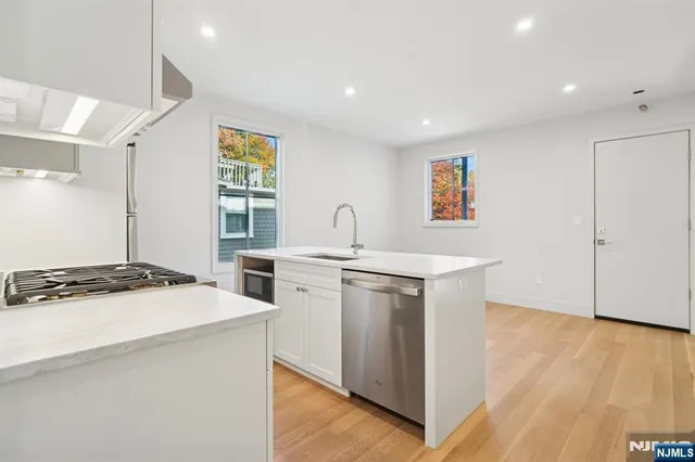a kitchen with white cabinets and refrigerator