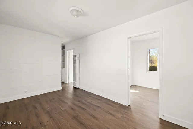 an empty room with wooden floor and closet