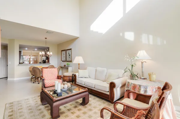 a view of a dining room and livingroom with furniture wooden floor a chandelier